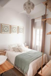 タリファにある2 - LA ESQUINA AZUL de TARIFA - ENJOY TARIFAの白いベッドルーム(ベッド1台、シャンデリア付)