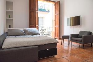 バレンシアにあるAmbrosio Flats Valencia - El Carmenのベッドルーム(ベッド1台、椅子、テレビ付)