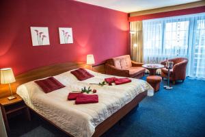 a bedroom with a large bed with red walls at Hotel Centrum Harrachov in Harrachov