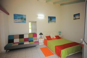 une chambre avec un lit et un canapé dans l'établissement Au Domaine Des Bougainvilliers, à Sainte-Rose