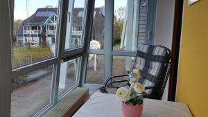 a vase of flowers sitting on a table in front of a window at Ferienwohnung Granitzblick 3 mit Wintergarten und Seeblick in Seedorf