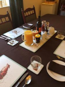 a table topped with plates and glasses of orange juice at The Old School B&B in Shawbury