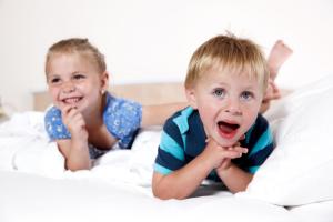 zwei Kinder liegen auf einem Bett in der Unterkunft Sonnenhotel Bayerischer Hof inklusive Eintritt ins AquaFit Erlebnisbad in Waldmünchen