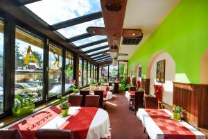 a restaurant with tables and chairs and green walls at Hotel Centrum Harrachov in Harrachov