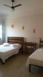 a bedroom with two beds and a ceiling fan at Avila Hotel in Boa Esperança