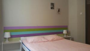 a bedroom with a rainbow stripe on the wall at Hostel Imbir in Toruń