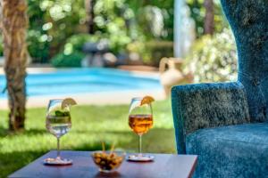 dos copas de vino en una mesa junto a una silla en Hotel Anatol en Merano