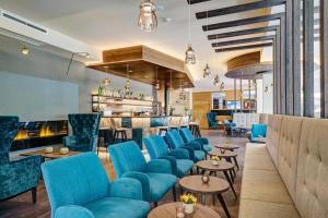 un vestíbulo con sillas y mesas azules y un bar en Hotel Anatol en Merano