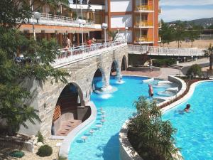 a swimming pool with a bridge and people in the water at Nessebar Beach Hotel in Sunny Beach