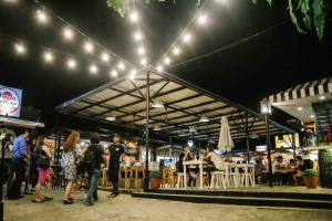 a group of people standing outside of a restaurant at Food District Hostel - Ortigas Kapitolyo in Manila +10 photos