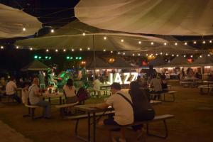 a group of people sitting at tables under a tent at Food District Hostel - Ortigas Kapitolyo in Manila