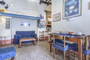 a living room with a blue chair and a table at Casa Quintani in Cortona