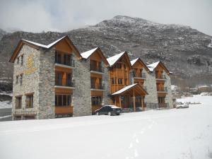 a large building in the snow in front of a mountain at Hotel Casa Chuldian in Sahun