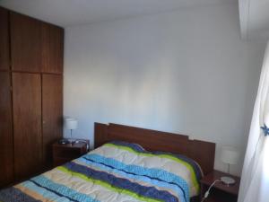 a bedroom with a bed and two night stands and two lamps at Como en Casa in Rosario