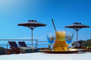 een drankje op een bord op een tafel met parasols bij Sakali Mansion in Pinakátai