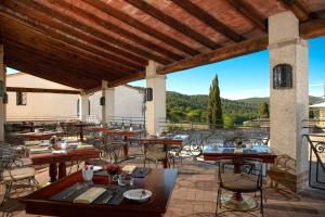 a restaurant with wooden tables and chairs on a patio at La Bagnaia Golf Resort in Bagnaia