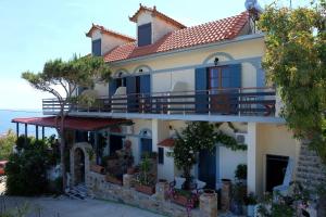 a large house with a balcony and the ocean at Pension Galini in Armenistis