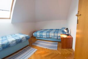 a room with two beds and a table with a lamp at Apartment Oreskovic in Otočac