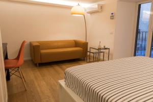 een kamer met een bed, een bank en een tafel bij Casa Fabrizio ai Gradoni di Chiaia in Napels