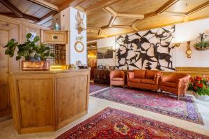 a living room filled with furniture and decor at Hotel Aquila in Cortina dʼAmpezzo