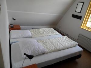 two beds in a small room with a window at Vakantiehuizen Hollandse Kust in Julianadorp