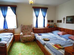 a bedroom with two twin beds and a chair at Chalupa Sněženka in Nýrsko