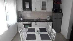 a kitchen with a table with chairs and a sink at Apartments A&A in Bibinje