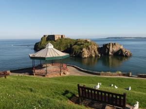 a park with a gazebo next to the ocean at Osnok in Tenby