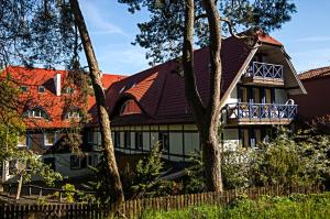 a large house with a brown roof at Hotel Jelita in Nida