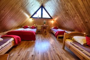 ザコパネにあるPokoje Gościnne Za Wnukiemの木造キャビン内のベッド3台