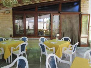 un restaurante con 2 mesas y sillas blancas en Mira Amalfi, en Agerola