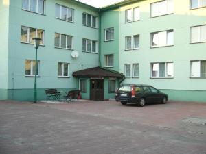 samochód zaparkowany na parkingu przed budynkiem w obiekcie Karet Obiekt Hotelowy w mieście Skoczów