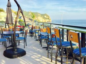 balkon ze stołami i krzesłami oraz oceanem w obiekcie Inn At Avila Beach w mieście Avila Beach