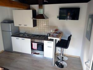 a small kitchen with a stove and a stool at Tiny house with a big heart in Postojna