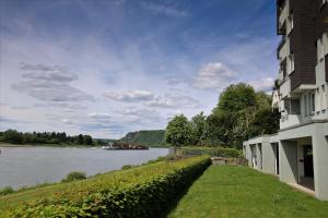 a building next to a river with a boat on it at RheinDesign River Promenade in Linz am Rhein