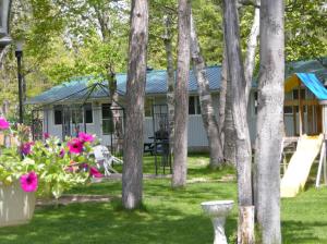 a house with a yard with trees and flowers at Birch Haven by the Beach in Wasaga Beach