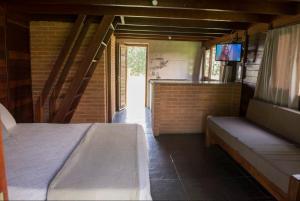 ein Schlafzimmer mit einem Bett und einem TV. in der Unterkunft Pousada Corujas in Itu