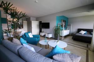 sala de estar con sofá azul y mesa en RheinDesign River Promenade, en Linz am Rhein