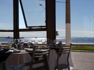 a table with wine glasses and a view of the ocean at Costanera Hotel in Puerto Madryn