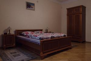 リヴィウにあるApartments in the Historical Centre - Lvivのベッドルーム1室(ベッド1台付)、木製キャビネットが備わります。