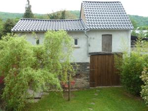 a white house with a wooden gate in a yard at Winzerhaus Andel in Bernkastel-Kues
