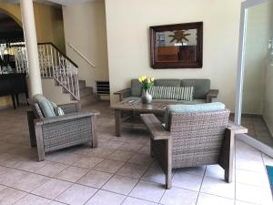 a living room with a table and wicker chairs at Hotel Villa del Sol in San Juan