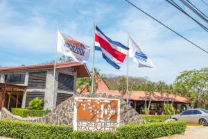 tres banderas volando delante de un edificio en Nacazcol - Playas del Coco en Coco