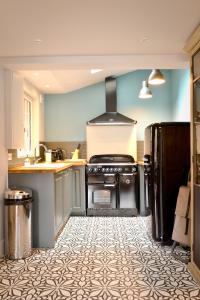 a kitchen with a stove and a refrigerator at La Maison de Pierre et Valérie Ste Catherine Honfleur in Honfleur