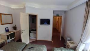 
a small room with a sink and a television at Guest House Šterk in Nova Gorica

