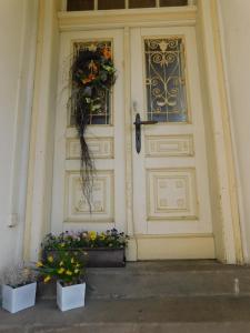 uma porta branca com duas flores à frente em Mladé Buky 261 em Mladé Buky