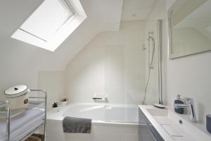 ein weißes Badezimmer mit Badewanne und Waschbecken in der Unterkunft La Maison de Pierre et Valérie Ste Catherine Honfleur in Honfleur