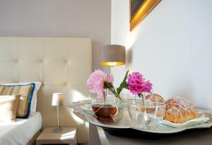 a tray with flowers and pastries on a table in a room at Antico Angelo - Residenza d'Epoca in Viterbo