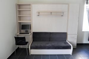 a bed in a room with a desk and a computer at Aux Jardins de L'Isle in Vienne