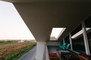 ein Haus mit einem Dach mit Dachfenstern auf der Veranda in der Unterkunft Secret Guest House in Gafanha da Vagueira